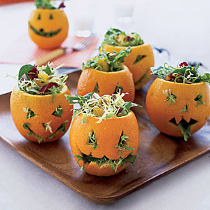 salada dentro de abóboras de Halloween esculpidas em laranjas