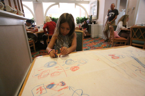Julia desenhando na mesa