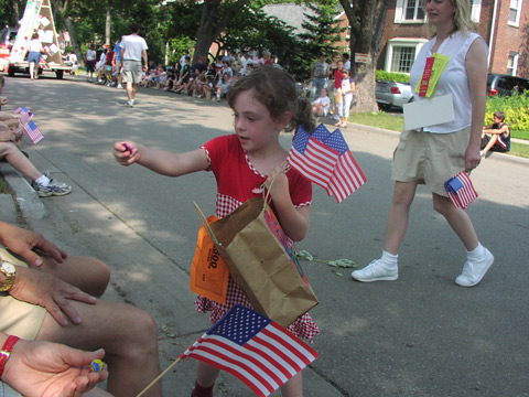 Menina distribuindo doces e bandeiras durante o desfile de 4 de julho em Michigan