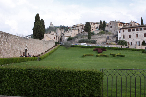 Em frente a Basílica tem esse gramado com a inscrição PAX. A Rocca Maggiore pode ser vista lá no alto.