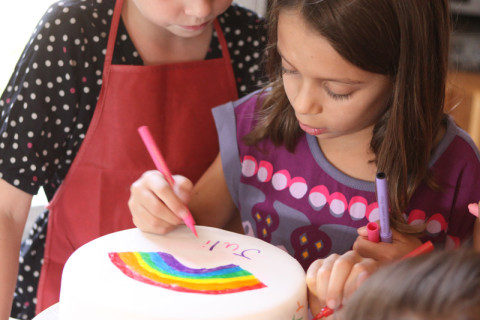 Julia desenhando no bolo